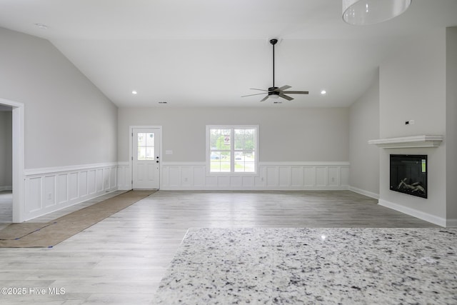 682 Crump Farm Rd, New Bern, NC 28562 - unfurnished living room featuring ceiling fan, wainscoting, vaulted ceiling, and wood finished floors