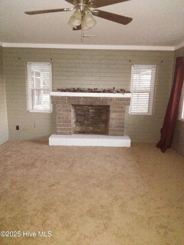 unfurnished living room with carpet floors, a fireplace, ceiling fan, and plenty of natural light