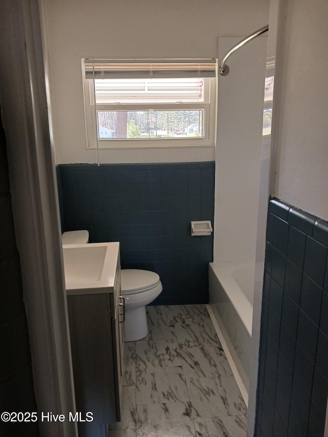 full bathroom featuring shower / bath combination, vanity, tile walls, and toilet