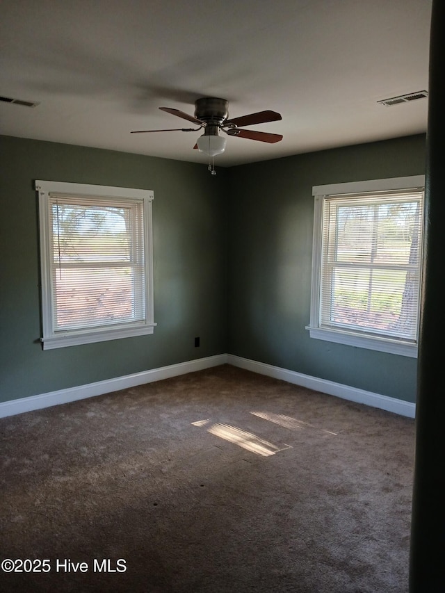 carpeted spare room with plenty of natural light and ceiling fan