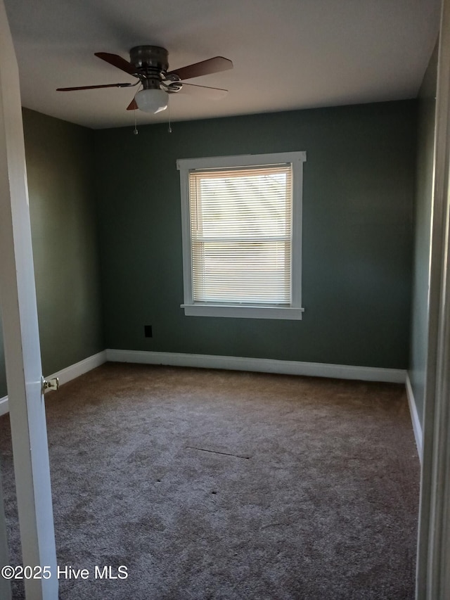 carpeted spare room featuring ceiling fan