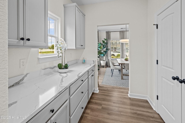 kitchen featuring dark wood-type flooring and light stone countertops