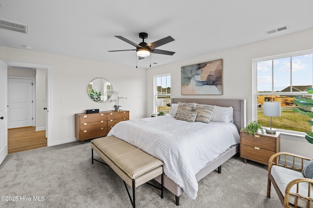 carpeted bedroom featuring ceiling fan and multiple windows