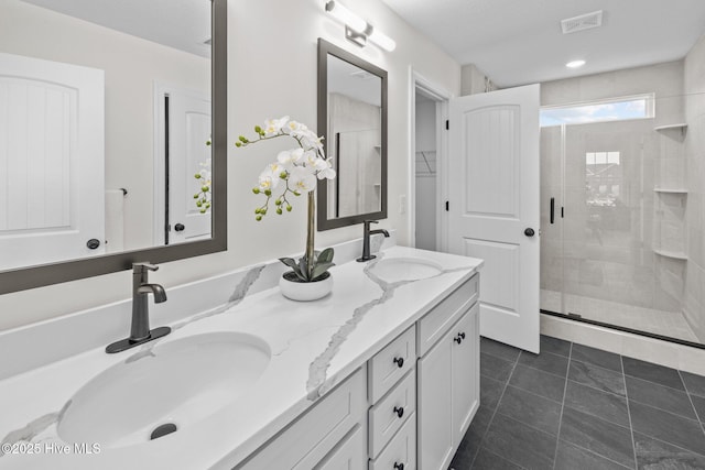 bathroom with tile patterned flooring, a shower with door, and vanity