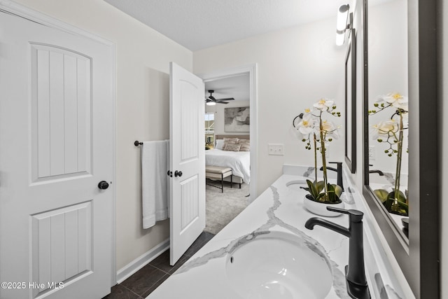 bathroom with a textured ceiling, tile patterned flooring, and vanity