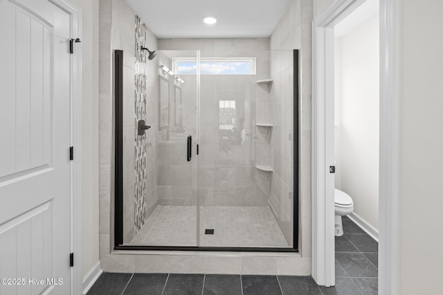 bathroom with an enclosed shower, tile patterned flooring, and toilet