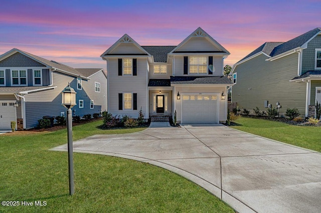 view of front of home with a garage and a lawn