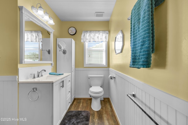 bathroom featuring vanity, wood-type flooring, and toilet