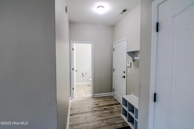 mudroom featuring visible vents, baseboards, and wood finished floors