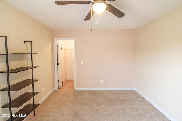 spare room with baseboards and light colored carpet