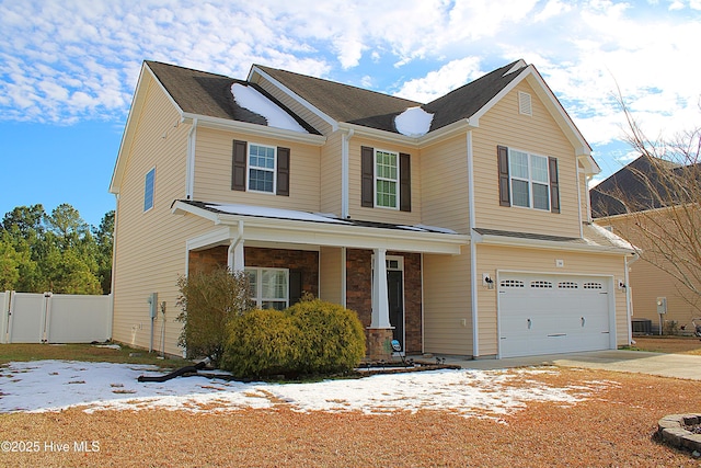 view of front of property featuring a garage and central AC unit