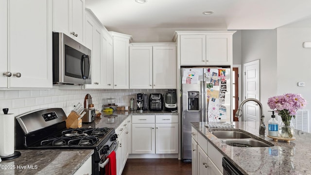 kitchen featuring light stone counters, appliances with stainless steel finishes, sink, and white cabinets