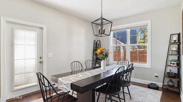 dining space with dark hardwood / wood-style flooring and an inviting chandelier