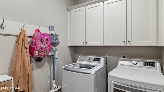 laundry room featuring cabinets and washing machine and clothes dryer