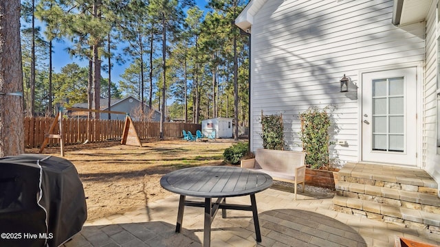 view of patio / terrace with area for grilling and a storage shed