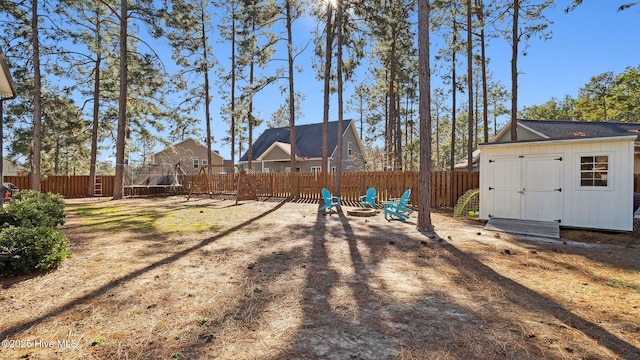 view of yard featuring a trampoline and a storage unit