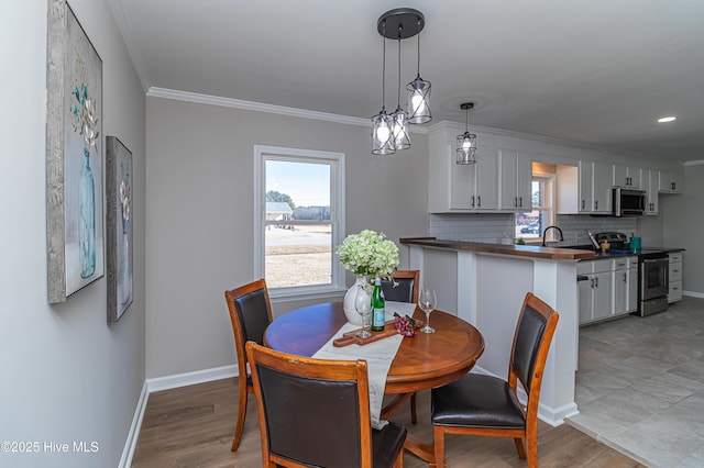 dining space featuring crown molding and light wood-type flooring