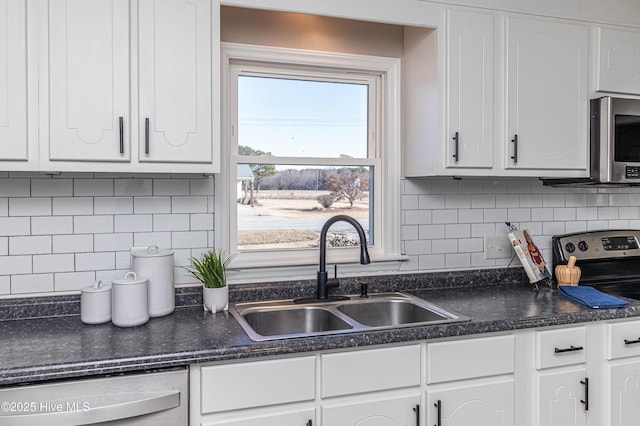 kitchen with white cabinetry, sink, tasteful backsplash, and appliances with stainless steel finishes