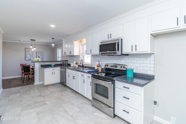 kitchen with ornamental molding, stainless steel appliances, hanging light fixtures, and white cabinets