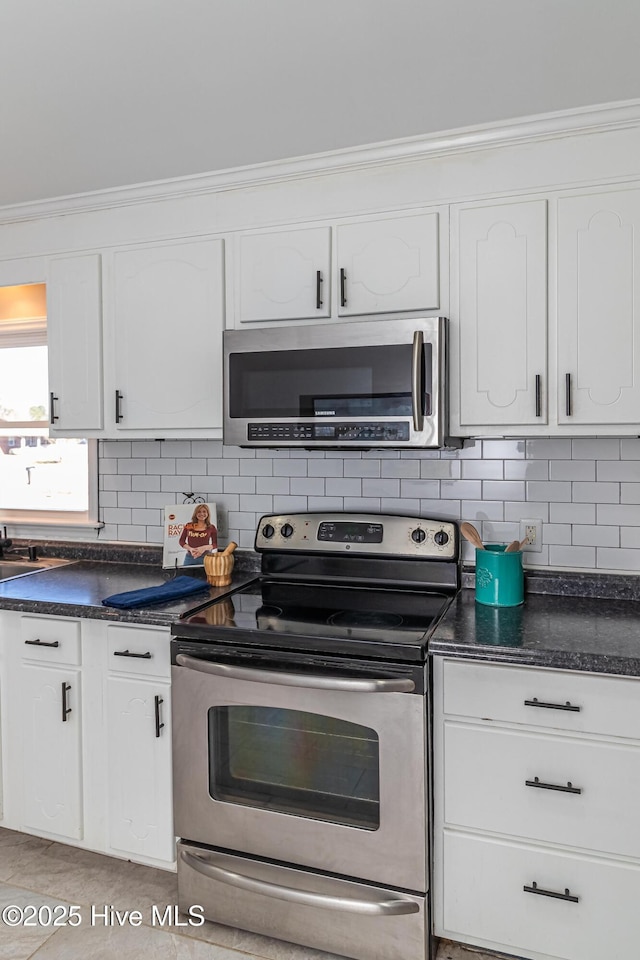 kitchen featuring white cabinetry, appliances with stainless steel finishes, crown molding, and decorative backsplash