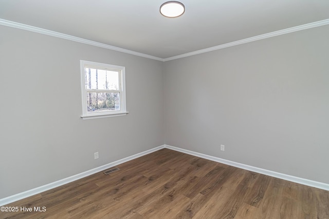 empty room with ornamental molding and dark hardwood / wood-style flooring