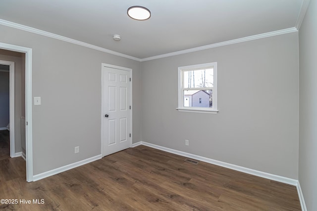 spare room with crown molding and dark hardwood / wood-style floors