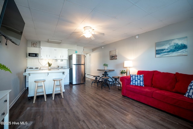 living room with dark wood-type flooring and ceiling fan