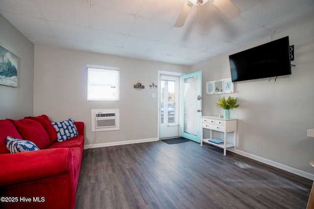 living area featuring ceiling fan, a wall mounted air conditioner, and dark hardwood / wood-style flooring