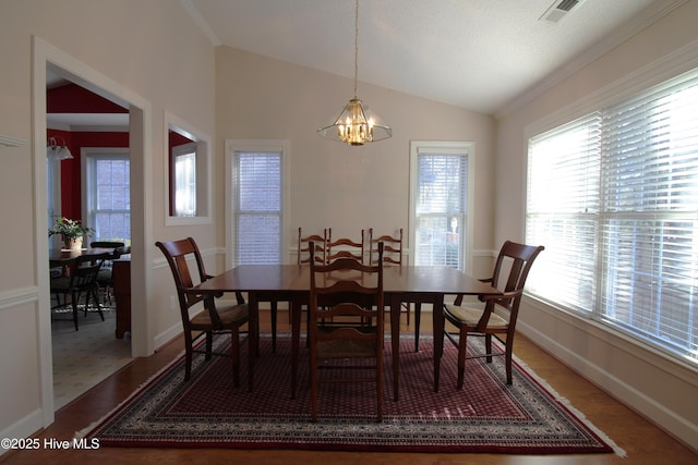 dining room featuring a wealth of natural light, a chandelier, and vaulted ceiling