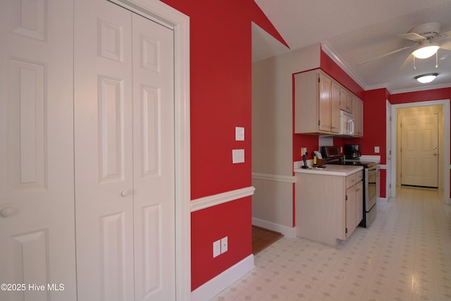 kitchen with crown molding, vaulted ceiling, ceiling fan, and electric stove