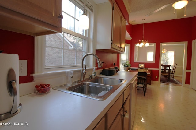 kitchen featuring sink, a notable chandelier, pendant lighting, and white dishwasher