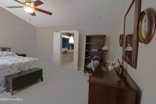 bedroom featuring light colored carpet, ensuite bath, and ceiling fan