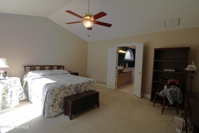 bedroom with ceiling fan, lofted ceiling, light carpet, and ensuite bath