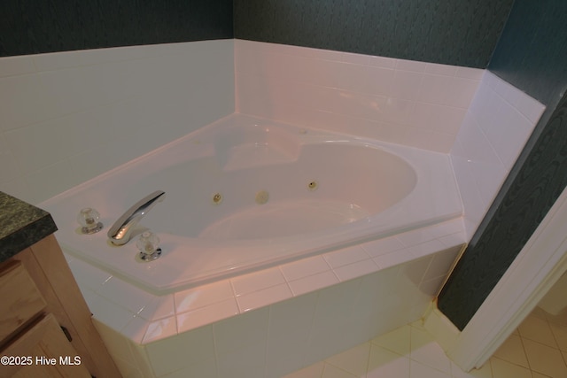 bathroom featuring vanity, a relaxing tiled tub, and tile patterned flooring