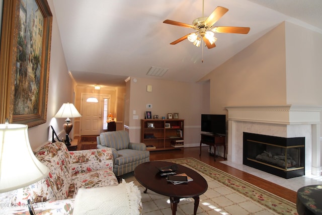 living room featuring ceiling fan, light hardwood / wood-style floors, a fireplace, and lofted ceiling