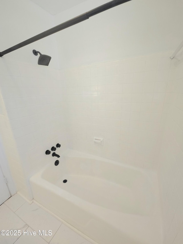 bathroom with tile patterned floors and tiled shower / bath combo