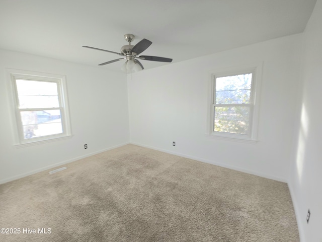 spare room with ceiling fan and carpet