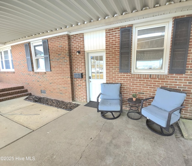 view of exterior entry with a patio area