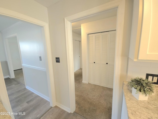 hall with light colored carpet