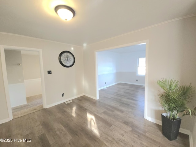 spare room featuring crown molding and wood-type flooring