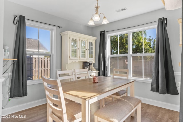 dining space with wood-type flooring and a notable chandelier