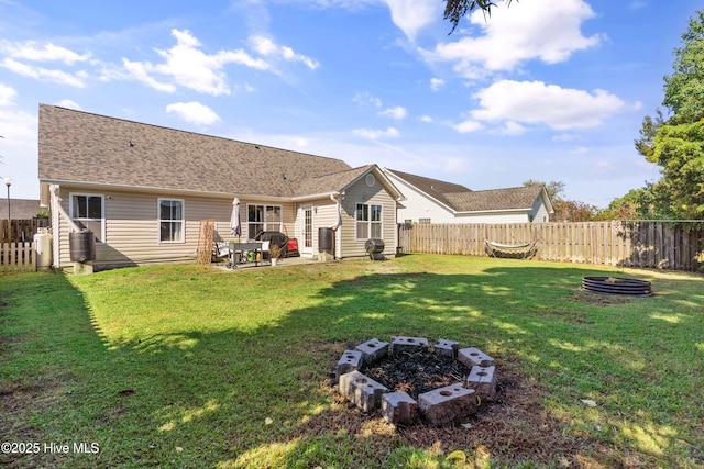 back of property with a patio, an outdoor fire pit, and a yard