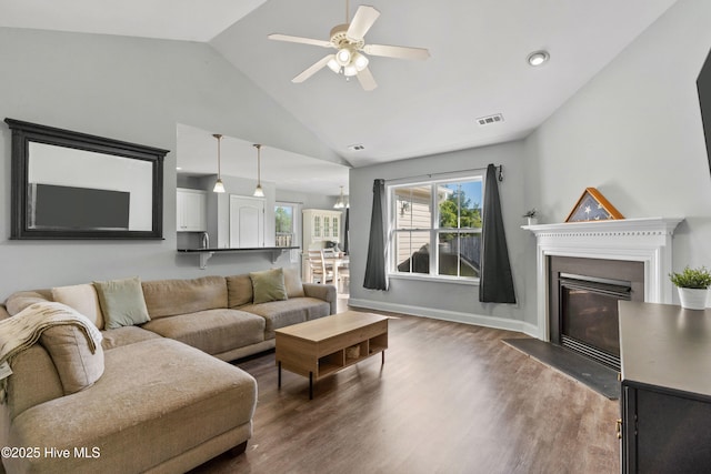 living room with hardwood / wood-style flooring, vaulted ceiling, and ceiling fan