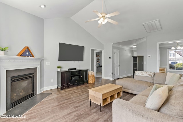 living room featuring ceiling fan with notable chandelier, wood-type flooring, crown molding, and lofted ceiling