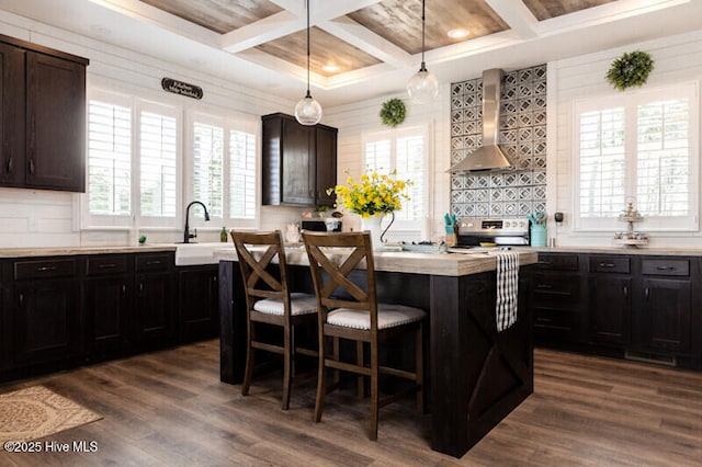 kitchen with a center island, coffered ceiling, stainless steel electric range oven, dark wood-type flooring, and wall chimney exhaust hood