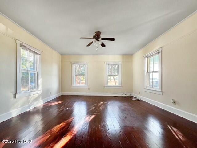 unfurnished room with ceiling fan and dark wood-type flooring