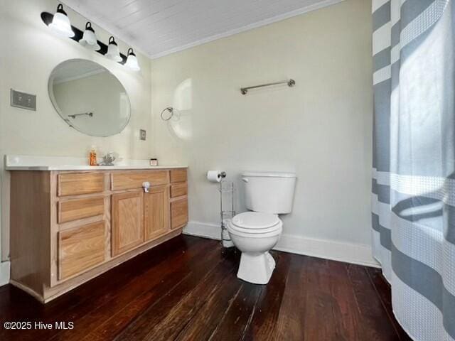 bathroom with toilet, vanity, crown molding, and hardwood / wood-style floors