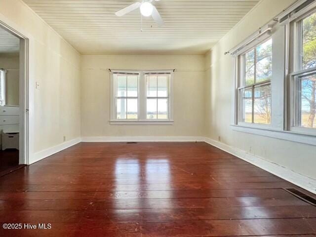 spare room with ceiling fan and dark wood-type flooring