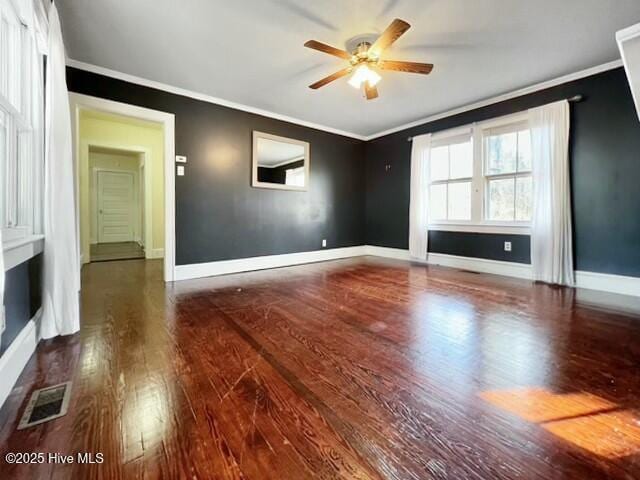 unfurnished living room with dark wood-type flooring, crown molding, and ceiling fan