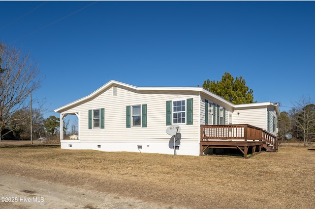 view of side of property featuring a lawn and a wooden deck